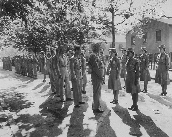 Image shows a group of men inspecting women and men (image courtesy of the U.S. Army Signal Corps Photograph Collection, Library of Virginia)